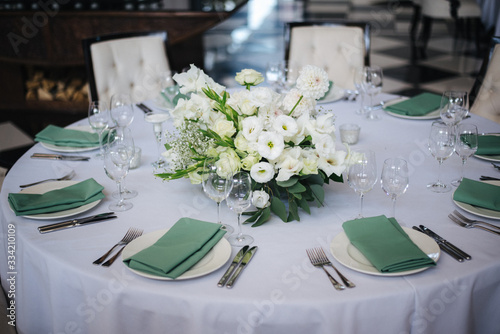 wedding table setting with flowers and green 
napkins