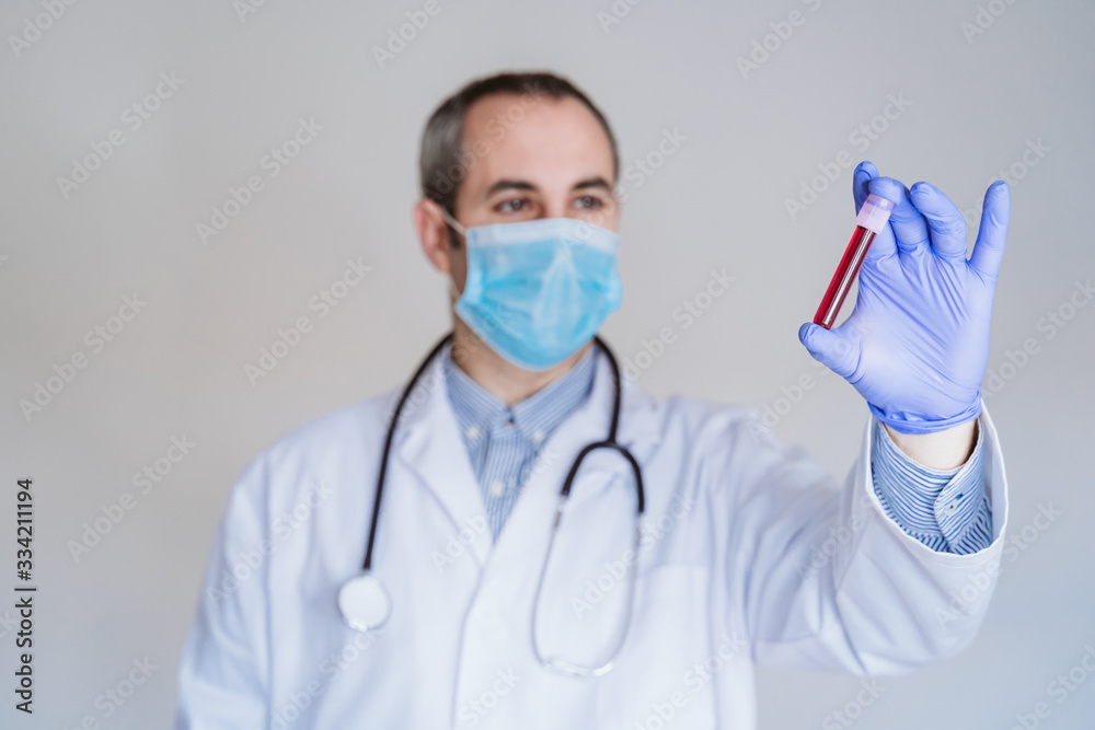 caucasian doctor man holding test tube with blood for 2019-nCoV analyzing. Chinese Coronavirus blood test concept. Covid-2019 caucasian doctor man holding test tube with blood for 2019-nCoV analyzing. Chinese Coronavirus blood test concept. Covid-2019