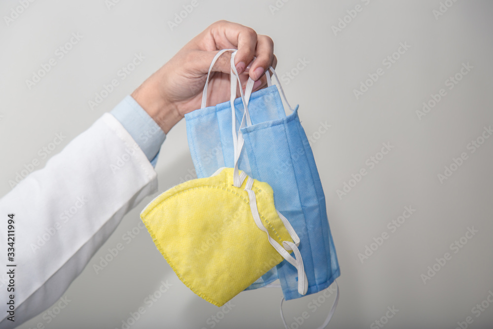 Doctor hand holding a medical face mask hand with hand sign Doctor hand holding a medical face mask hand with hand sign