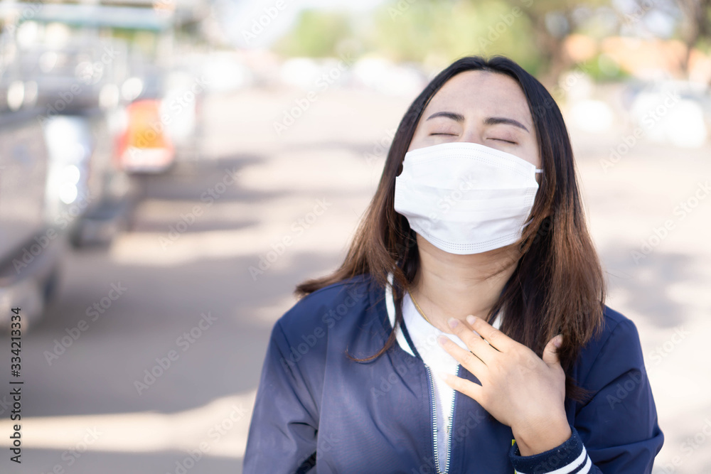 Closeup woman wearing face mask for protect air polution or virus covid 19 with chest pain , health care and medical concept