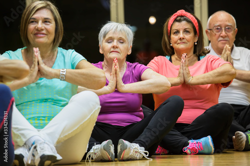 Gruppo di anziane si dedica allo yoga in palestra