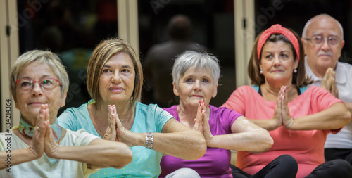 Gruppo di anziane si dedica allo yoga in palestra
