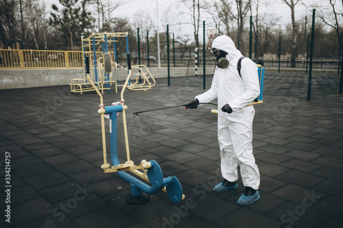 Cleaning and Disinfection on the playground in the sity complex amid the coronavirus epidemic Teams for disinfection efforts Infection prevention and control of epidemic Protective suit and mask