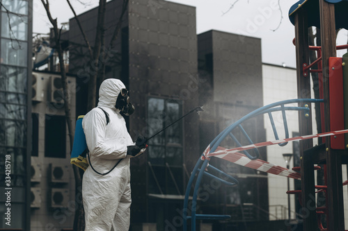 Cleaning and Disinfection on the playground in the sity complex amid the coronavirus epidemic Teams for disinfection efforts Infection prevention and control of epidemic Protective suit and mask