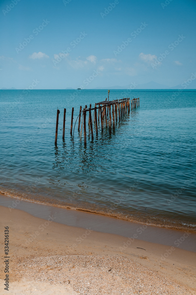 Old abandoned wooden pier on the beach
