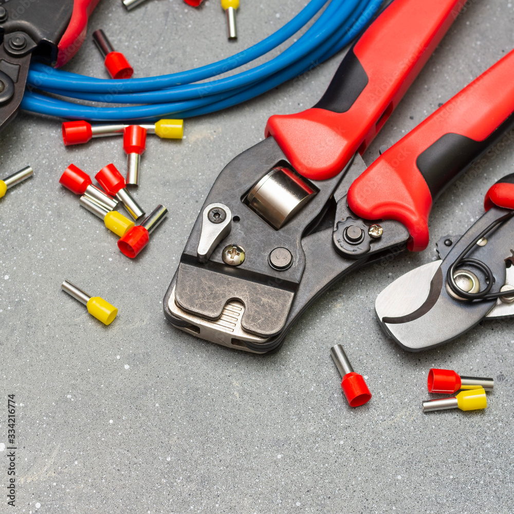 Tool for crimping stranded electrical wires. Crimping tool for an electrician or Builder on a grey concrete background	