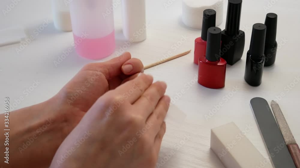 The girl wipes her nails with liquid. The girl wipes her nails with liquid.