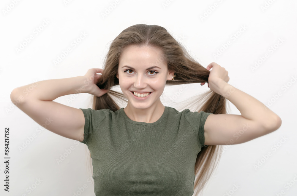 Smiling girl straightens her hair, shares on ponytails Smiling girl straightens her hair, shares on ponytails