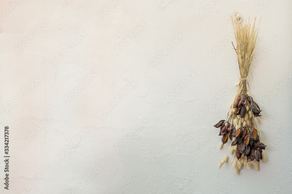 Naklejka premium Preserved flowers bunch on a white wall 