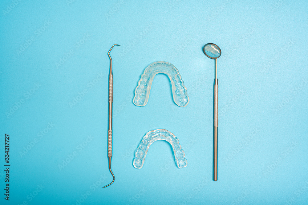Transparent dental aligner next to dentist mirror, copy space. Transparent dental aligner next to dentist mirror, copy space.