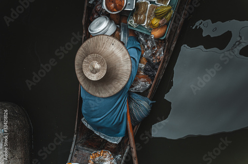 Man on boat in Damnoen Saduak Floating Market in Bangkok Thainland  photo