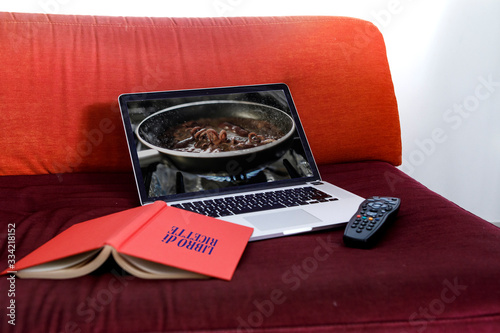 computer portatile su tavolo di legno con un immagine di food e un libretto delle ricette photo