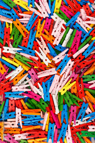 Multi-colored wooden clothespins as a full-screen texture and background. Decorative clothespins for creativity.