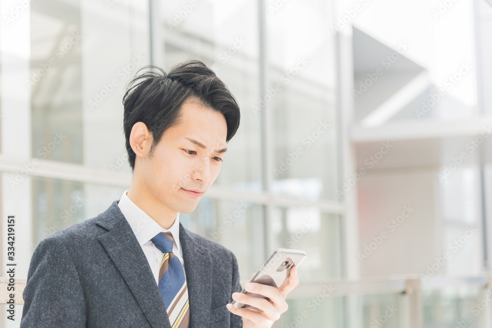 スマートフォンを手に持つビジネスマン スマートフォンを手に持つビジネスマン