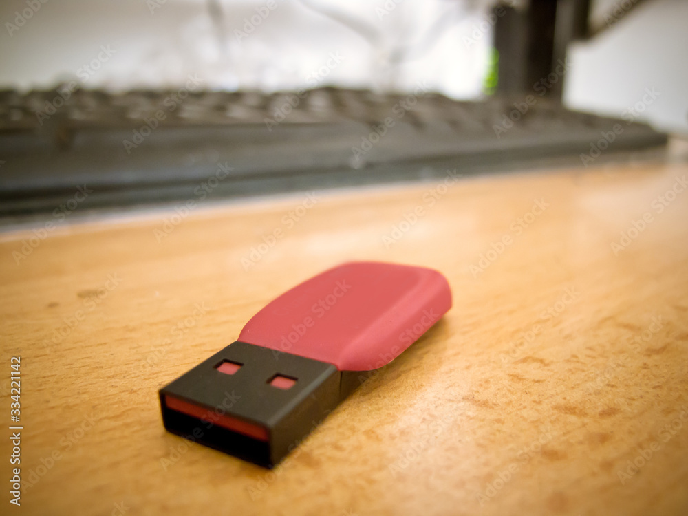 A small flash drive on a wooden office table. A small flash drive on a wooden office table.