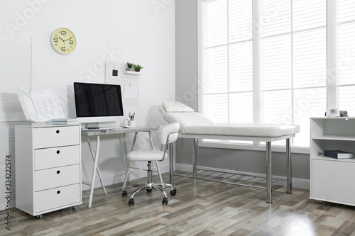 Modern medical office interior with computer and examination table © New Africa