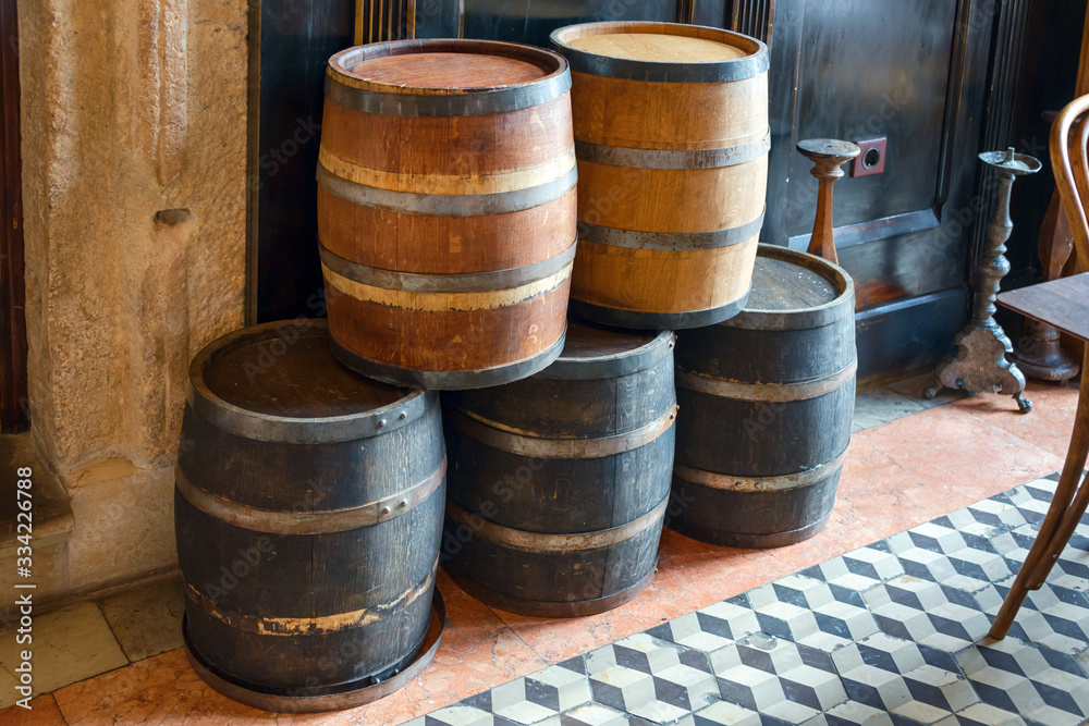 Oak barrels for storing wine, liquor and beer. Old wooden barrel with rusty hoops in pub, bar decoration Oak barrels for storing wine, liquor and beer. Old wooden barrel with rusty hoops in pub, bar decoration