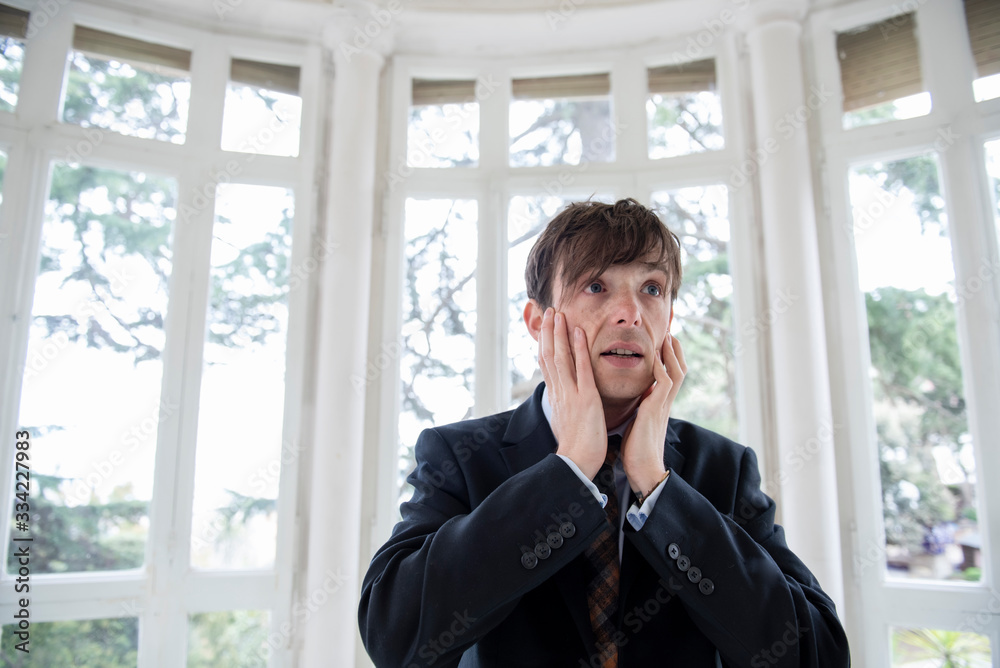 man in a suit touching his face in despair man in a suit touching his face in despair