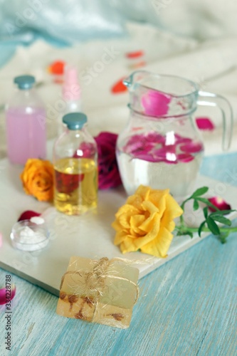 Fresh roses, soap, petals, water and oil on the table for the preparation of natural cosmetics, spa, hygiene procedures, healthy lifestyle