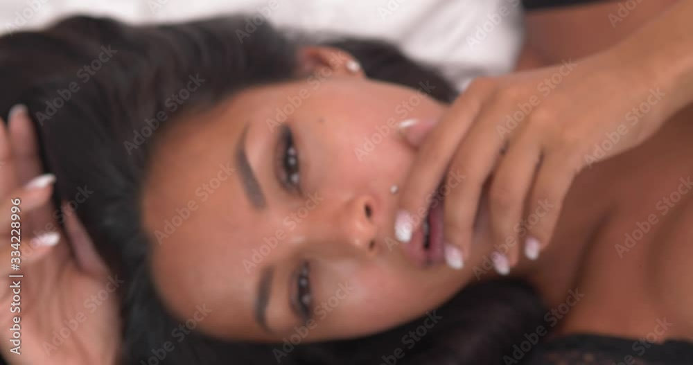 Portrait of beauty brunette woman in black lingerie posing on the bed - video in slow motion