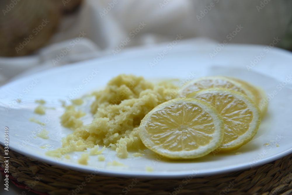 Preparing a sweet hot drink with ginger, lemon and honey for easing cold symptoms and feeling better M Preparing a sweet hot drink with ginger, lemon and honey for easing cold symptoms and feeling better M