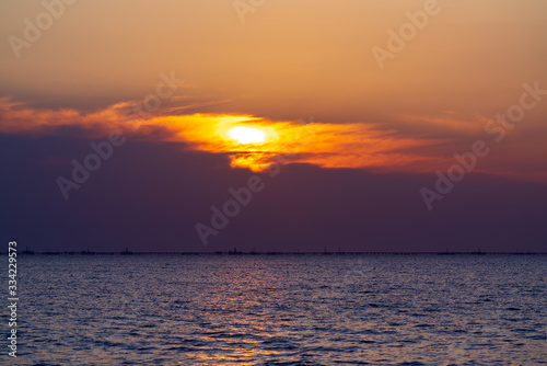 Colorful sunrise at sea  oil platforms in distance