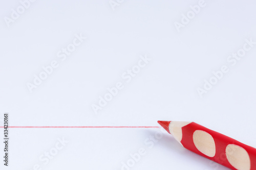 Canvas Print Red pencil and red line on a white background with copy space