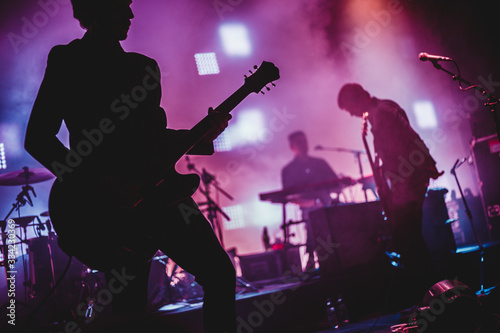 Stampa su tela Blurred background light on rock concert with silhouette of musicians