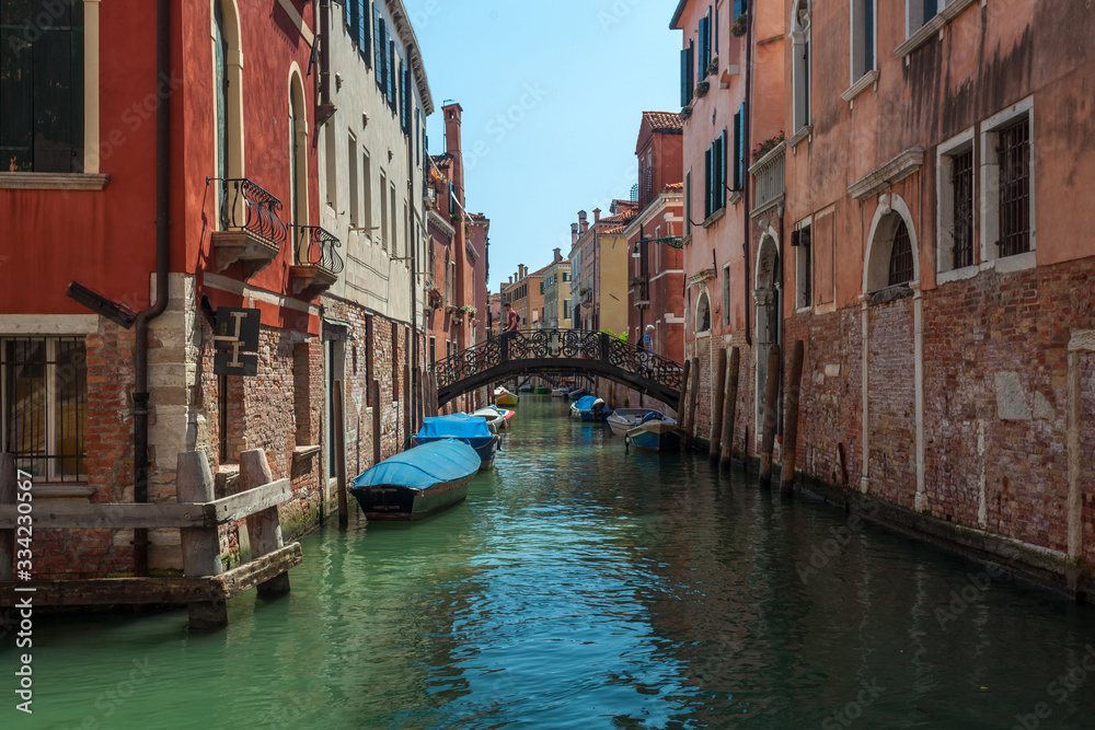 View of narrow Canal with boats and gondolas in Venice, Italy