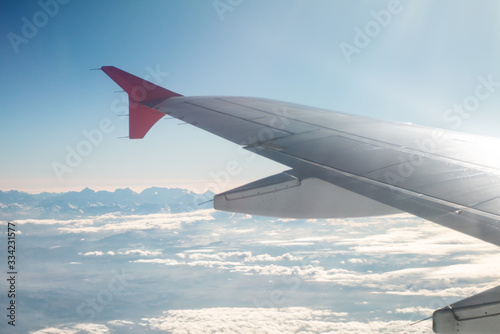 Passenger airplane flying above the mountain peaks. Wing view