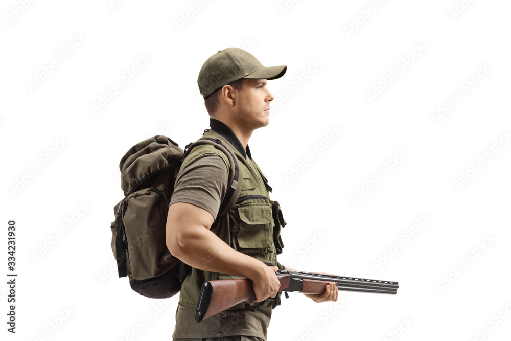 Young male hunter walking and holding a shotgun Young male hunter walking and holding a shotgun
