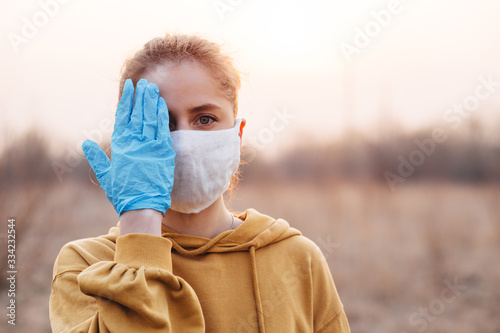 COVID-19 Pandemic Coronavirus Girl in mask and blue gloves during quarantine photo