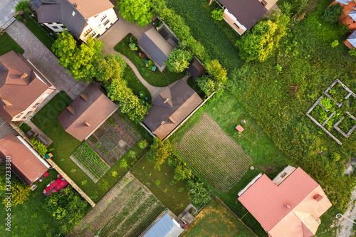 Aerial landscape of small town or village with rows of residential homes and green trees.