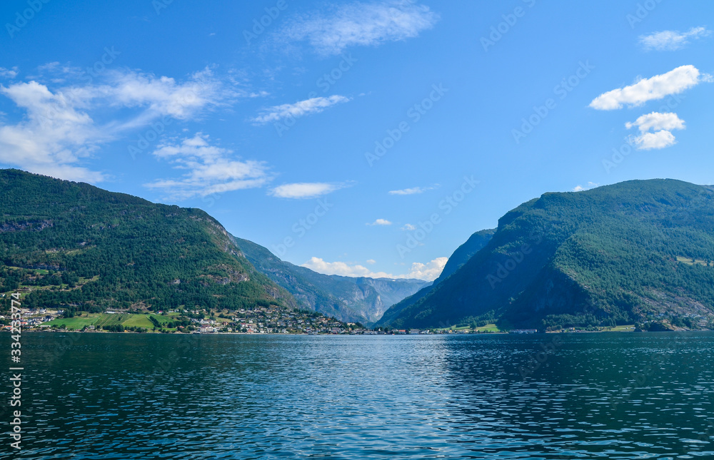 Scenic view to village at end of Aurlandsfjorden on west coast in early summer. Flam, Aurland, Norway, Scandinavia. Tourism vacation and travel background