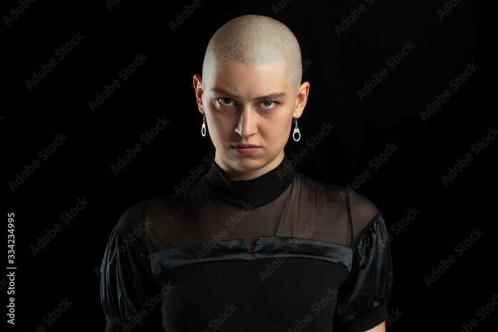 Serious, mystic. Monochrome portrait of young caucasian bald woman isolated on black studio background. Beautiful female model. Human emotions, facial expression, sales, ad concept. Youth culture. Serious, mystic. Monochrome portrait of young caucasian bald woman isolated on black studio background. Beautiful female model. Human emotions, facial expression, sales, ad concept. Youth culture.