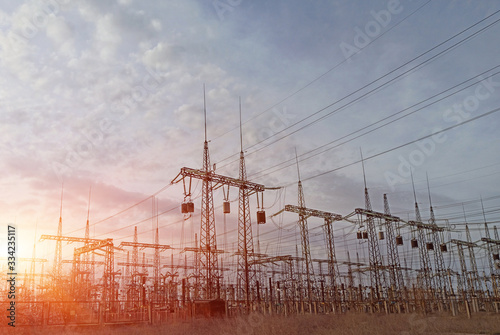 High-voltage power lines at sunset or sunrise. High voltage electric transmission tower