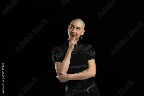 Thoughtful, dreamful. Monochrome portrait of young caucasian bald woman isolated on black studio background. Beautiful female model. Human emotions, facial expression, sales, ad concept. Youth culture