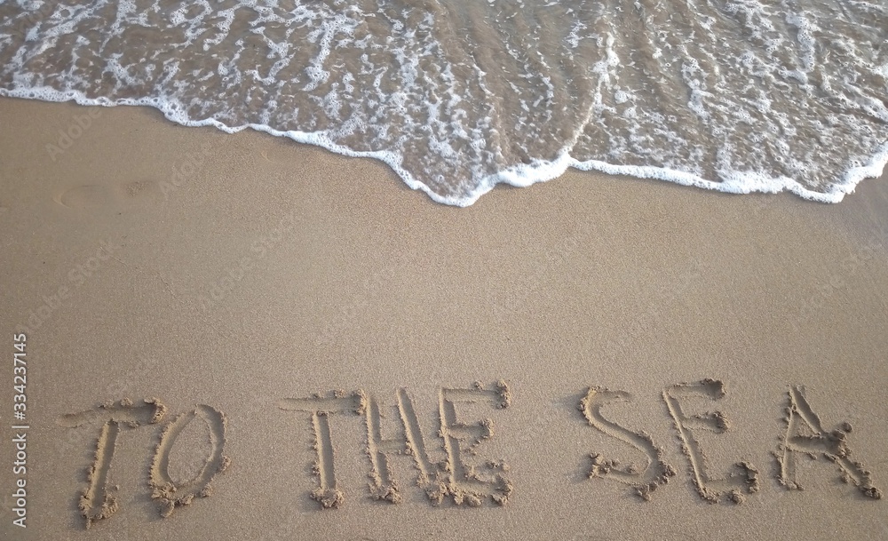 Title To the sea on a sandy beach with a sea wave above. Vacation concept.