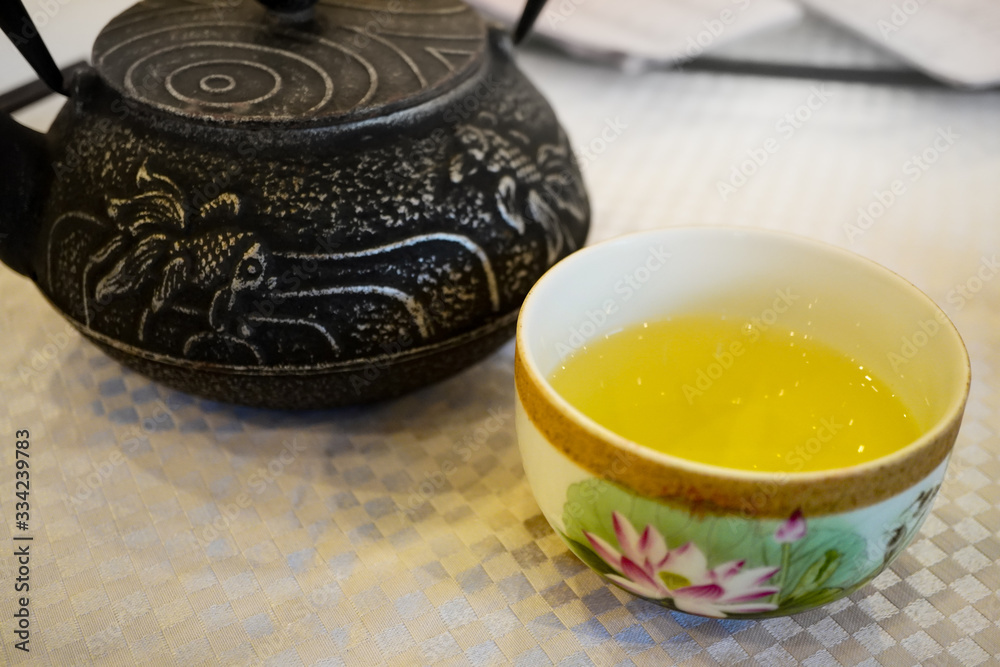 Chinese tea pot and a cup of Chinese tea or Tea service on a white table Chinese tea pot and a cup of Chinese tea or Tea service on a white table