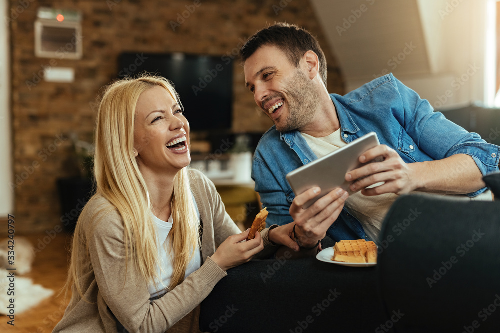 Cheerful couple having fun while using digital tablet at home. Cheerful couple having fun while using digital tablet at home.