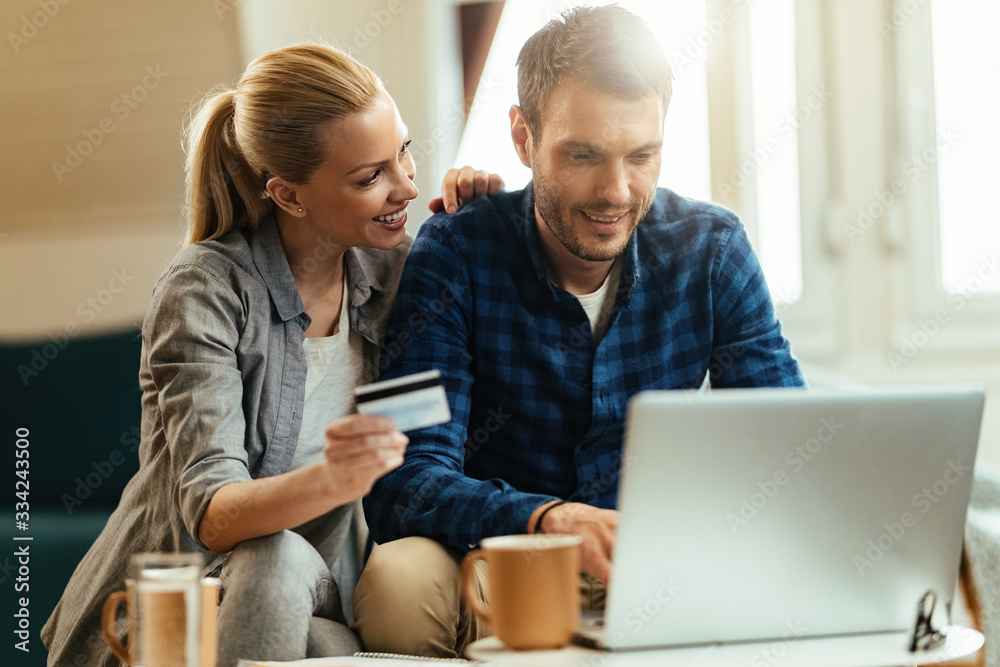 © Drazen - Happy couple shopping online with credit card and laptop at home. © Drazen - Happy couple shopping online with credit card and laptop at home.