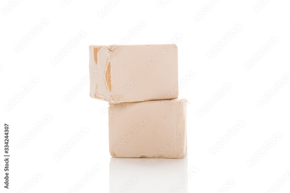 Obraz premium Two yeast cubes for bread making isolated on white background.
