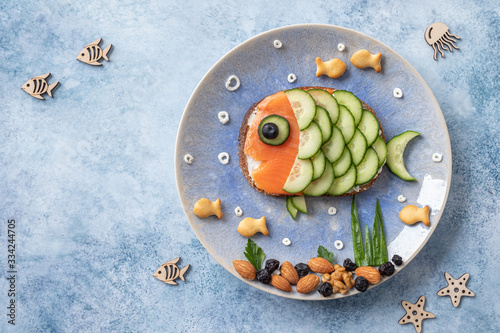 Funny salmon fish sandwich with cucumber for kids lunch photo