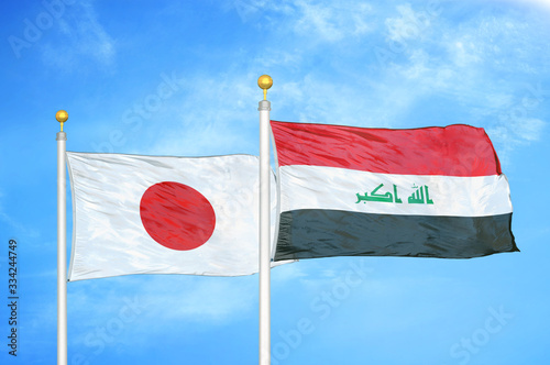 Japan and Iraq two flags on flagpoles and blue cloudy sky