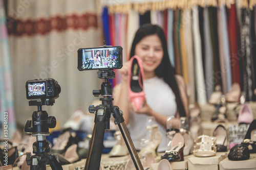 young woman Asian selling shoes online by live streaming  Young female vlogger recording content for her online fashion channel on social media 