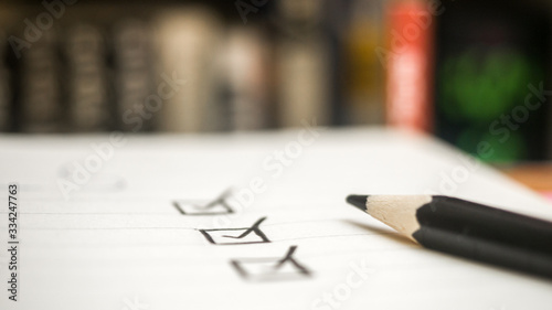 Fotografie Black marking on checklist box with pencil close up book background Checklist co