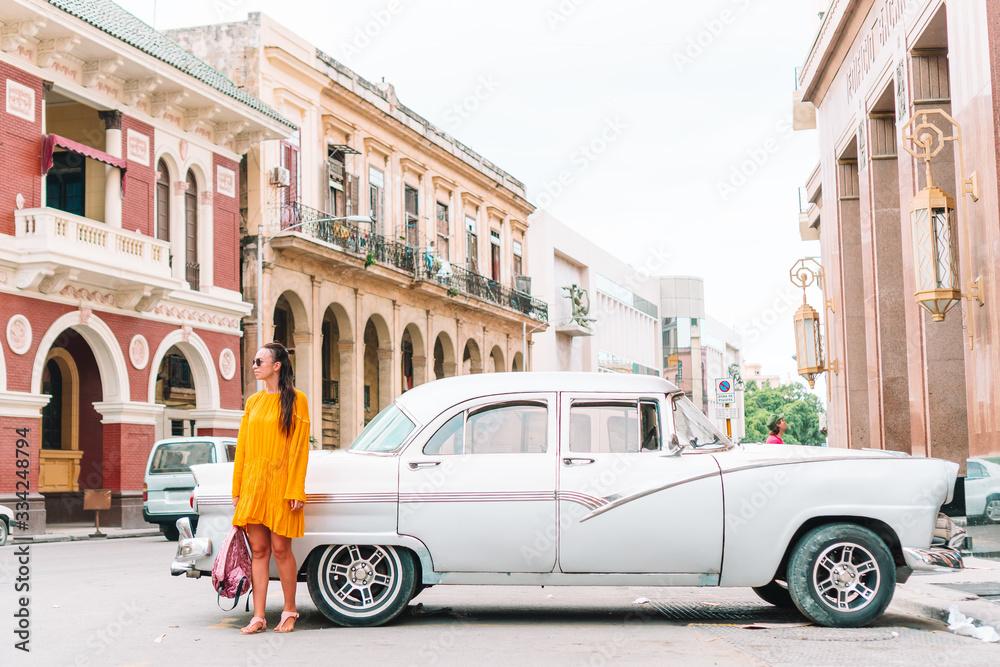 Tourist girl in popular area in Havana, Cuba. Back view of young woman traveler