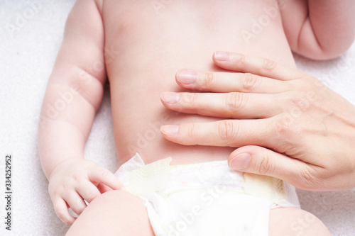 Woman doing massage against colic tummy to baby
