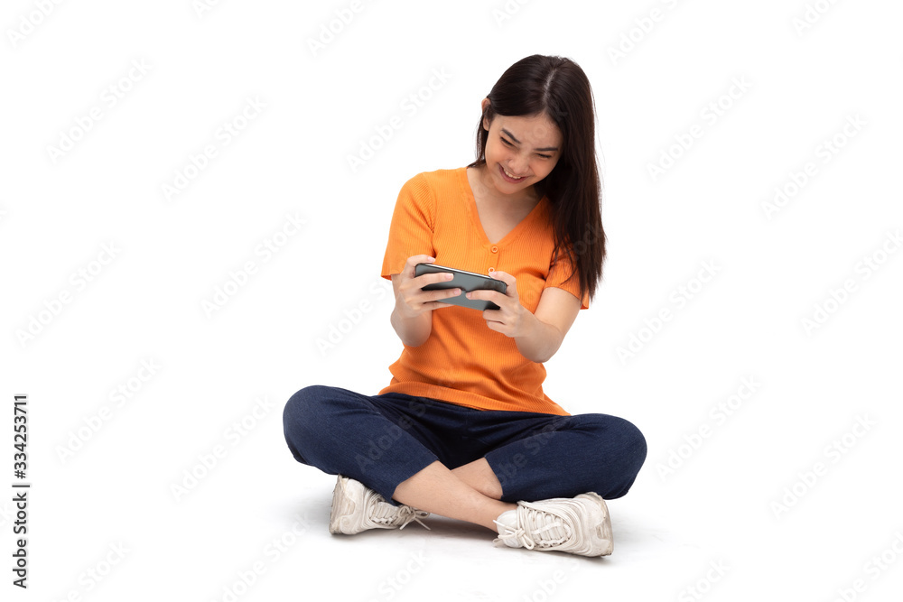 Young Asian woman wow expression and sitting on floor while using smartphone playing game application isolated on white background