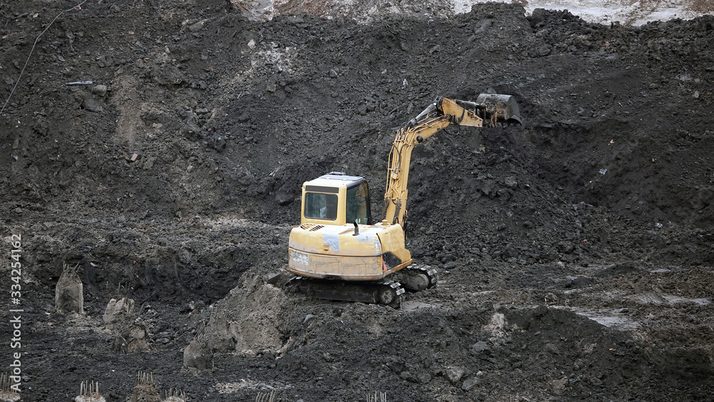 Tractors and excavators work on the construction of the foundation zero cycle